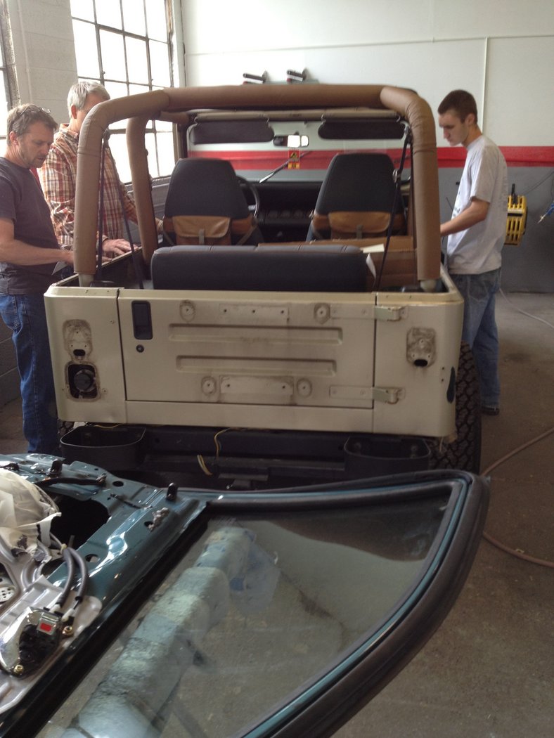 Jeep in the body shop.  Discussing paint and other items with repairmen.