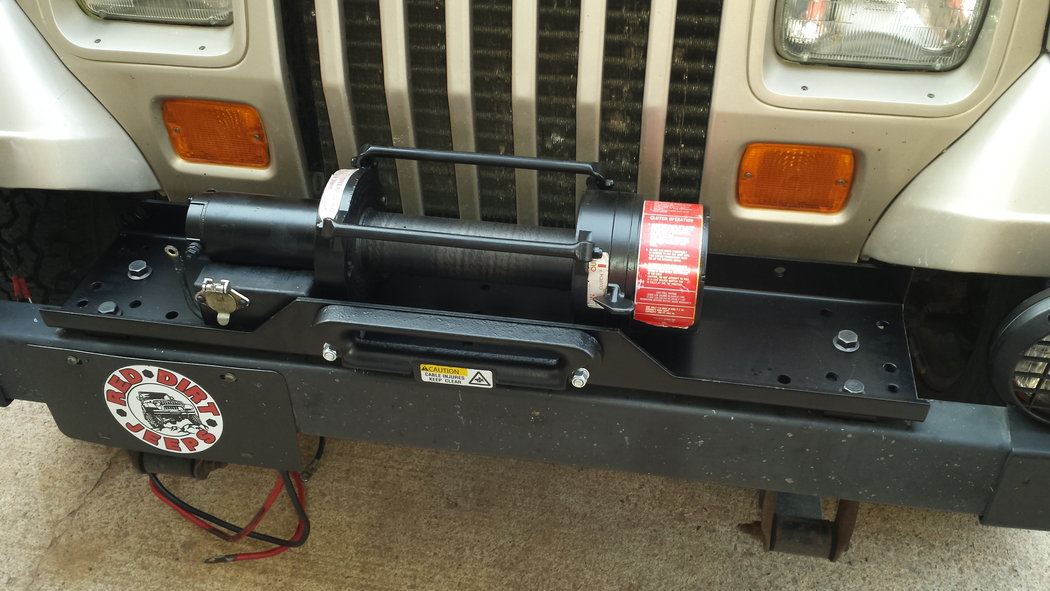 Refurbished and painted winch and mounting plate on the Jeep.